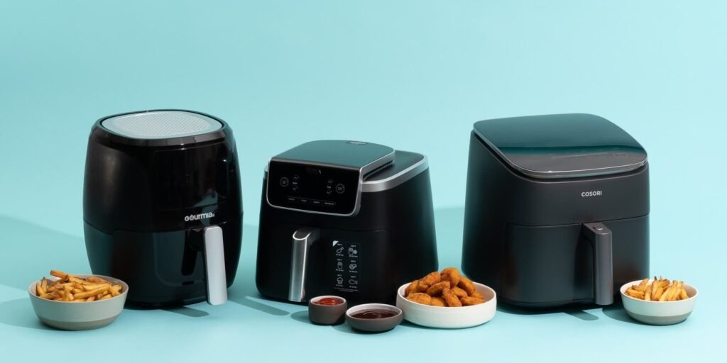 Modern air fryer on white quartz countertop with fresh vegetables and natural light