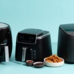 Modern air fryer on white quartz countertop with fresh vegetables and natural light