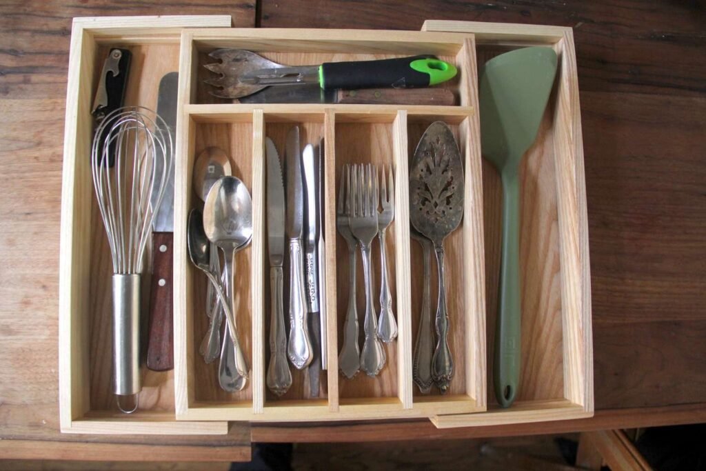 Neatly organized kitchen drawer with utensils and cutlery in modern organizers.