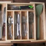 Neatly organized kitchen drawer with utensils and cutlery in modern organizers.