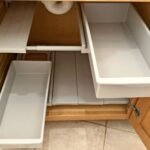 Organized under-sink cabinet with modular storage bins for small kitchens