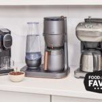 Sleek stainless steel coffee maker on wooden counter with morning light